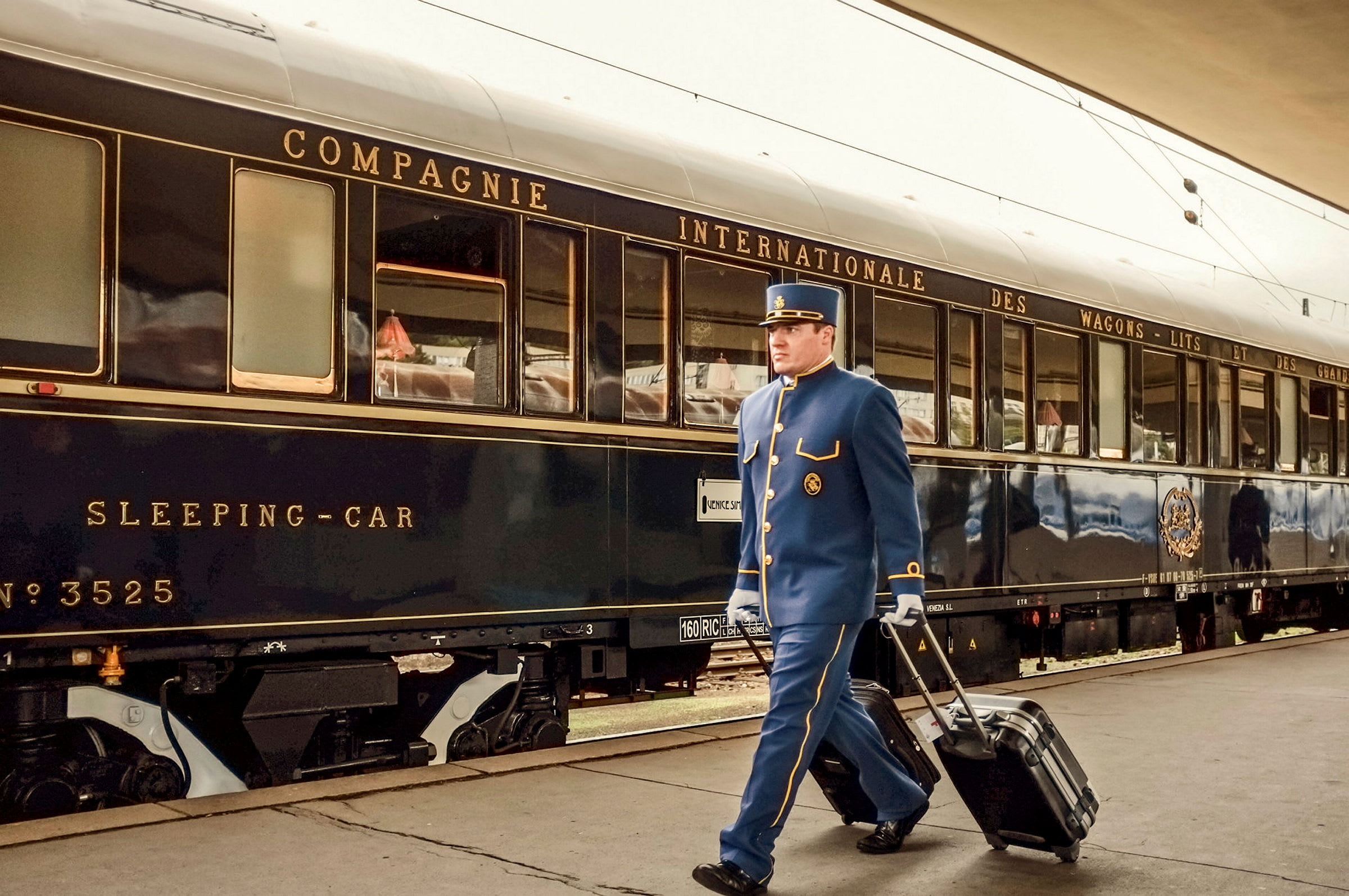 En person i uniform går med en resväska vid en lyxig tågkupé. (AI-genererad text)