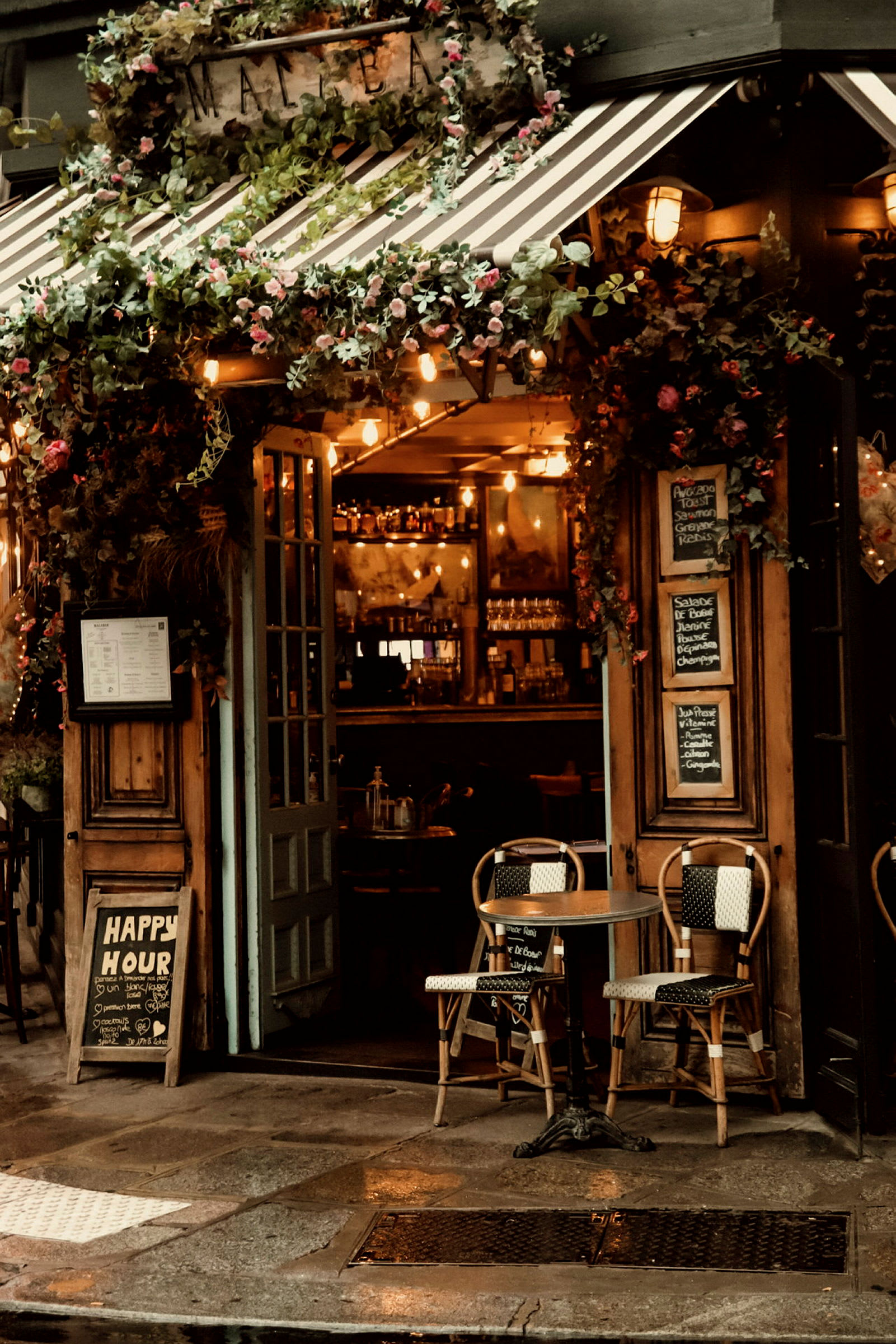 En mysigt inredd restaurangentré med två stolar och ett bord utanför. (AI-genererad text)