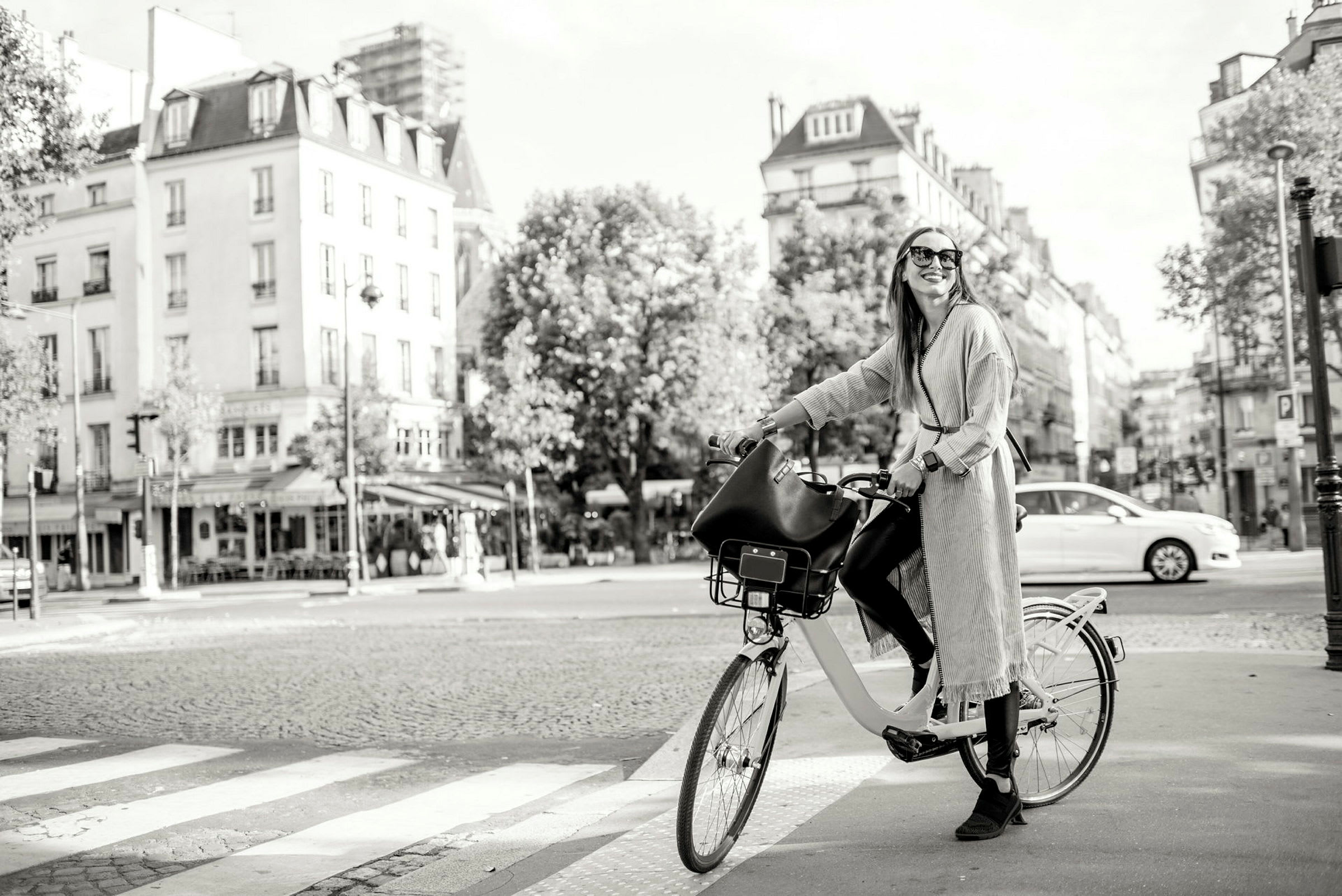 En person står med en cykel på ett övergångsställe i en stad. (AI-genererad text)