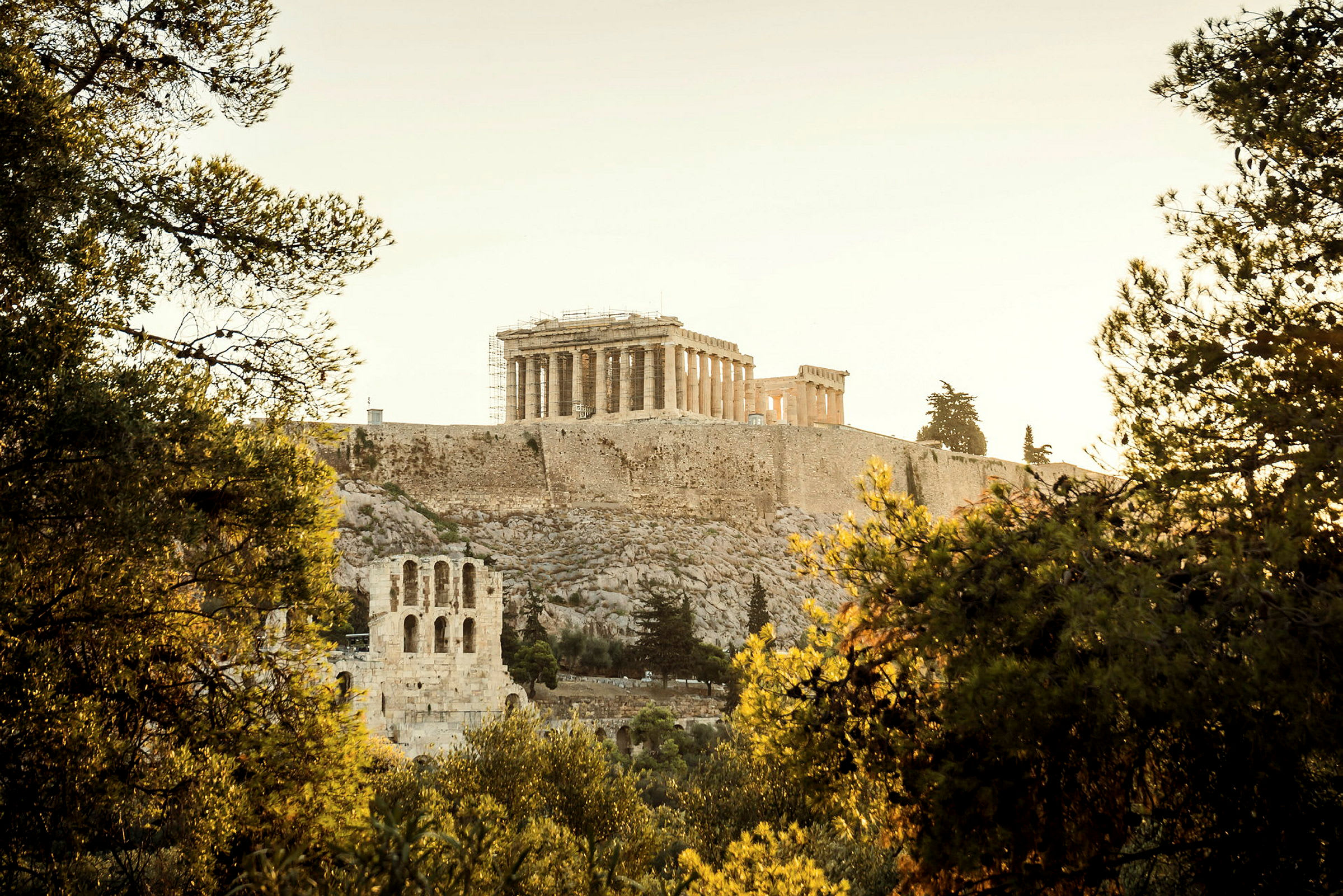 Akropolis i Aten, omgiven av träd och grönska. (AI-genererad text)