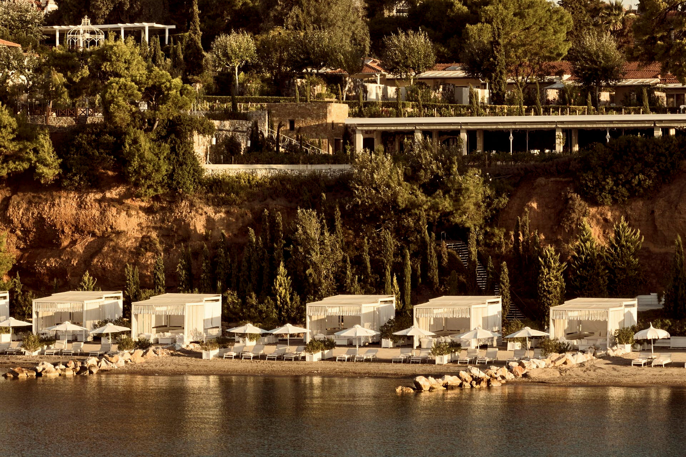 Lyxiga strandpaviljonger vid ett sluttande klipplandskap. (AI-genererad text)