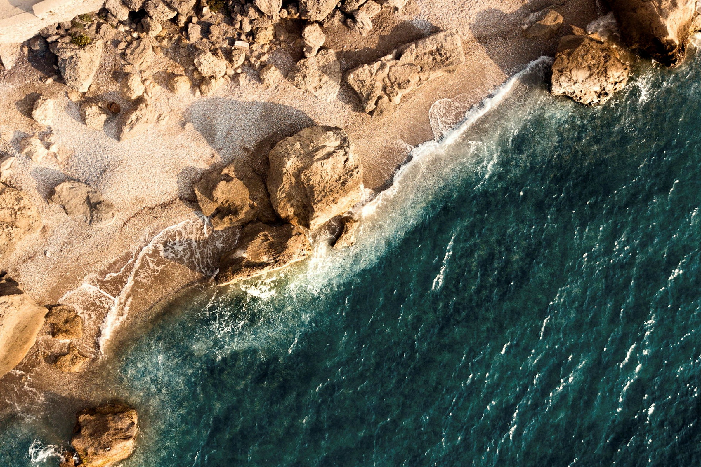 Flygvy av en stenig strand vid havet. (AI-genererad text)