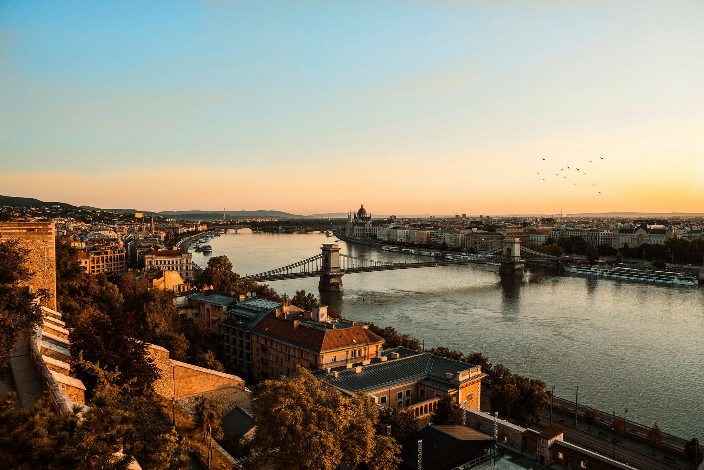 Bild av Budapest med Széchenyi-kedjebron och floden Donau vid solnedgången. (AI-genererad text)