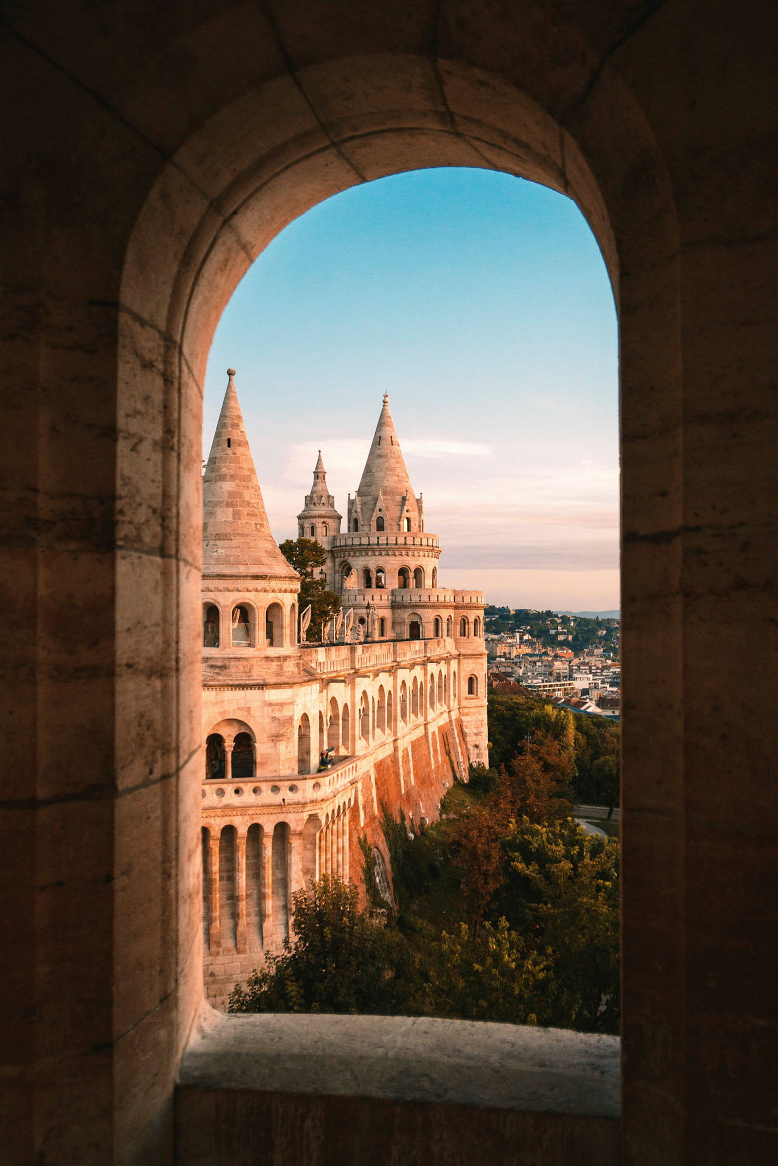 Vy mot Fisherman's Bastion i Budapest genom en stenbåge. (AI-genererad text)
