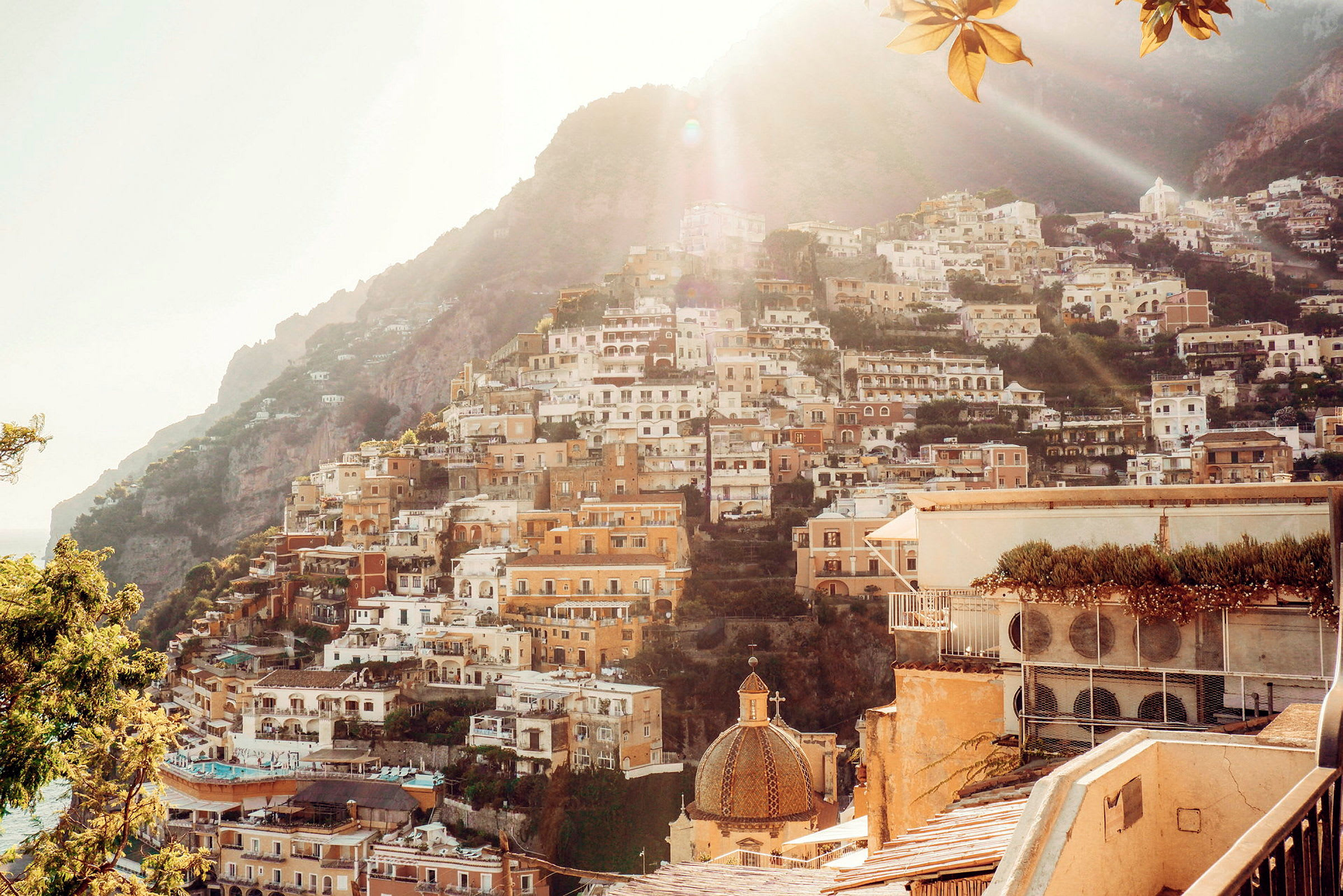 En bild på en italiensk kustby med byggnader terrasserade längs en bergssluttning. (AI-genererad text)