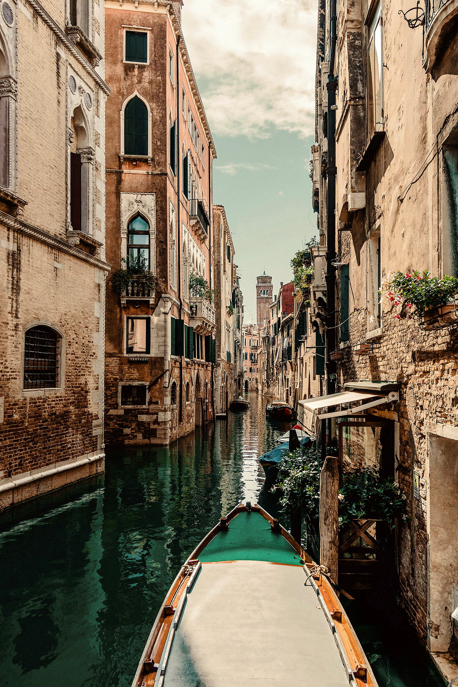 En kanal omgiven av gamla byggnader i Venedig, med en båt i förgrunden. (AI-genererad text)