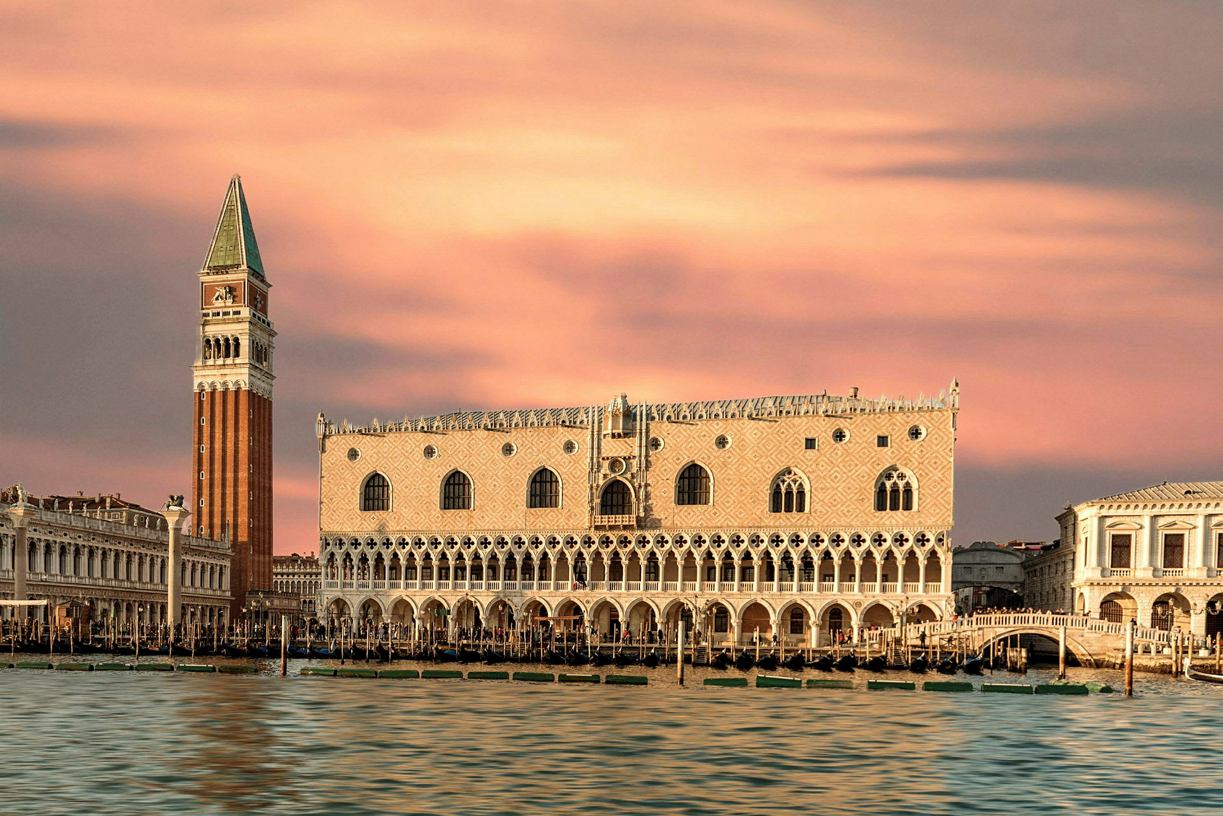 Bild av Dogepalatset och Kampanilen i Venedig med rosa kvällshimmel. (AI-genererad text)