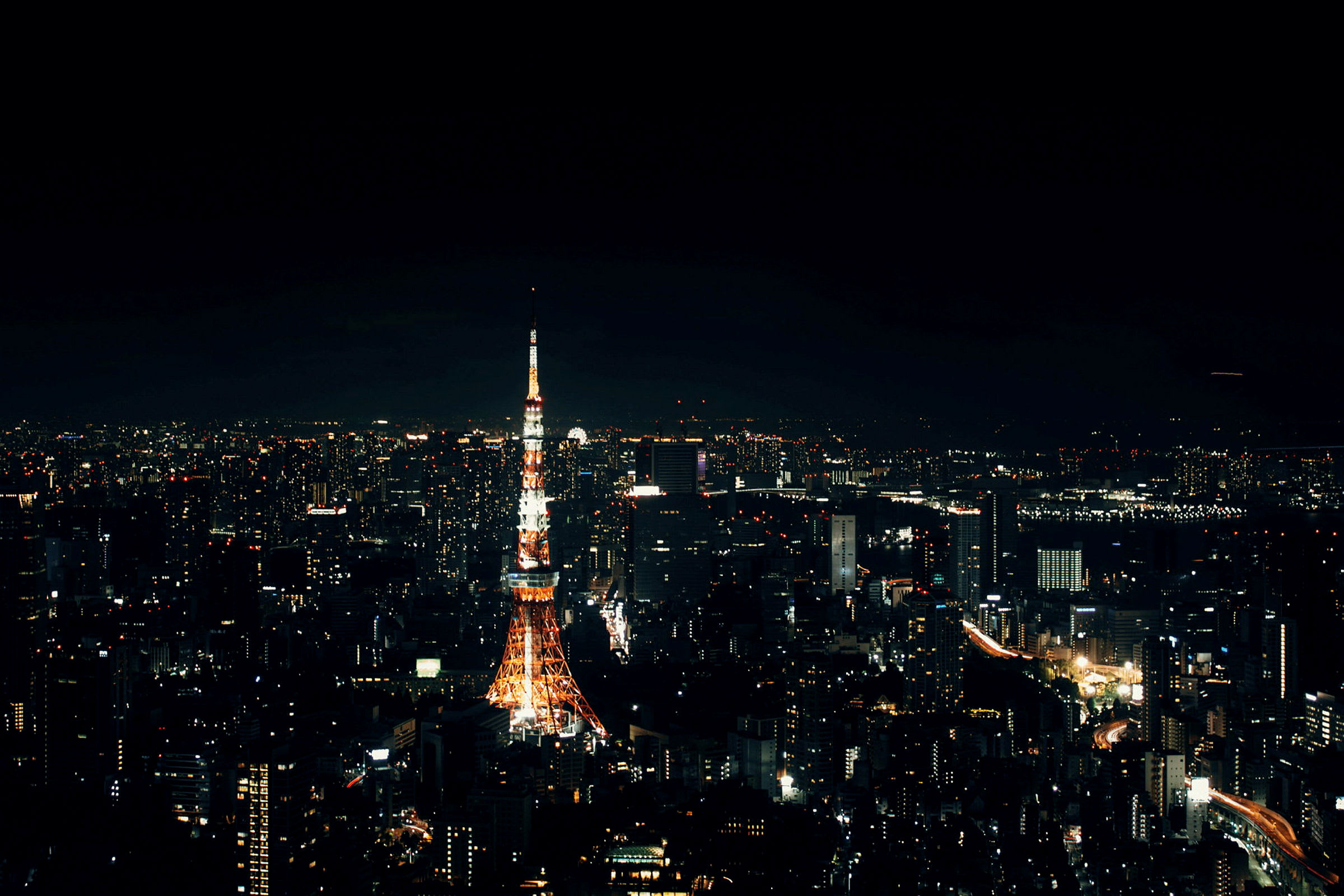 Tokyo Tower lyser upp natthimlen, omgiven av stadsljus. (AI-genererad text)