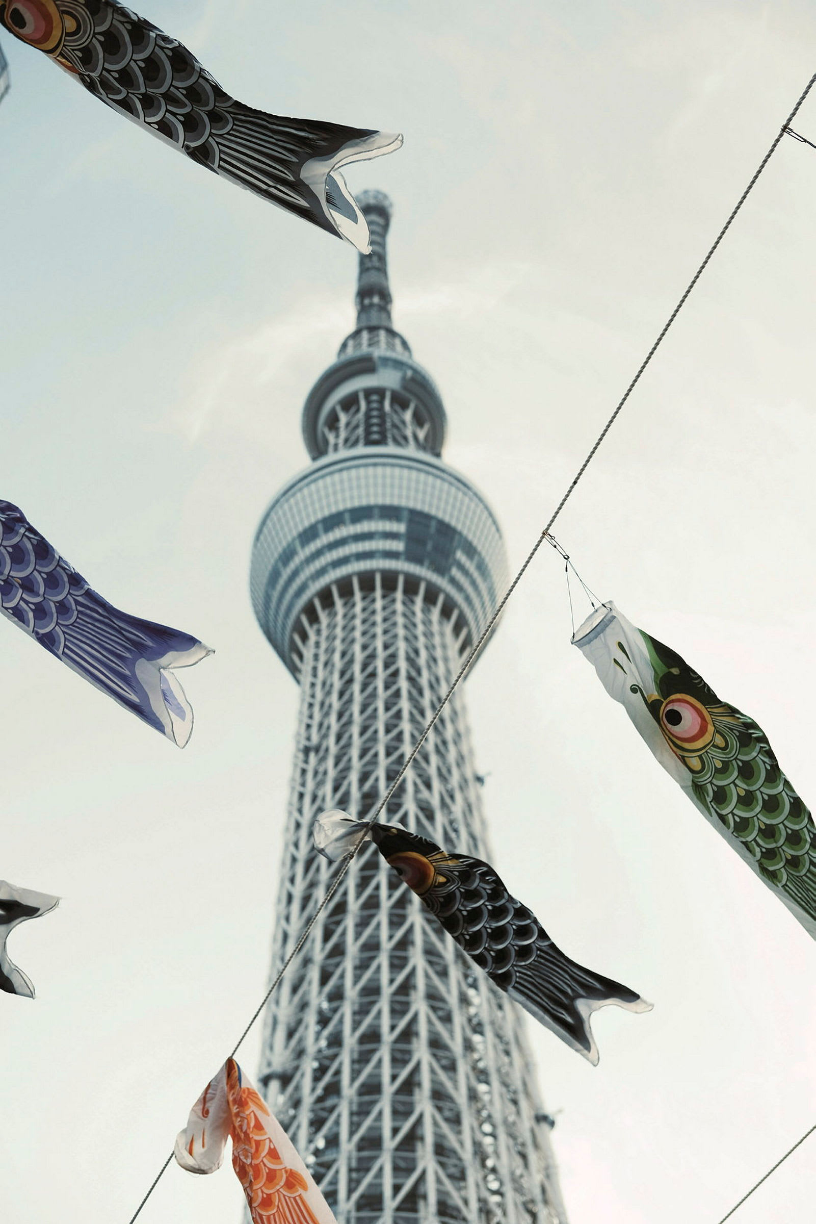 Färgglada fiskformade dekorationer hängande framför Tokyo Skytree. (AI-genererad text)