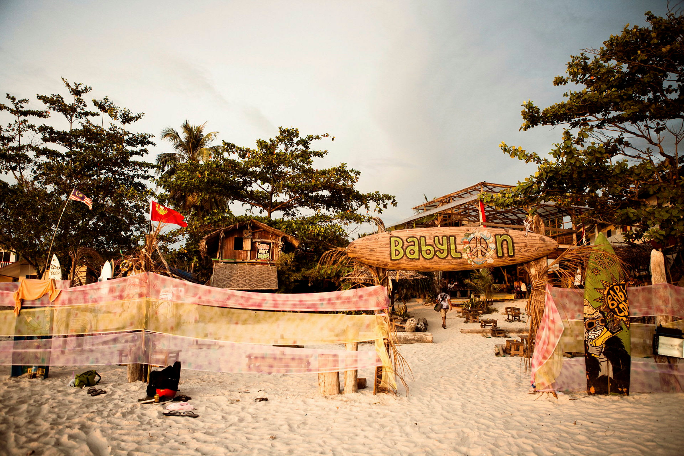 Ingången till en strandbar med skyltar och färgglad dekoration. (AI-genererad text)