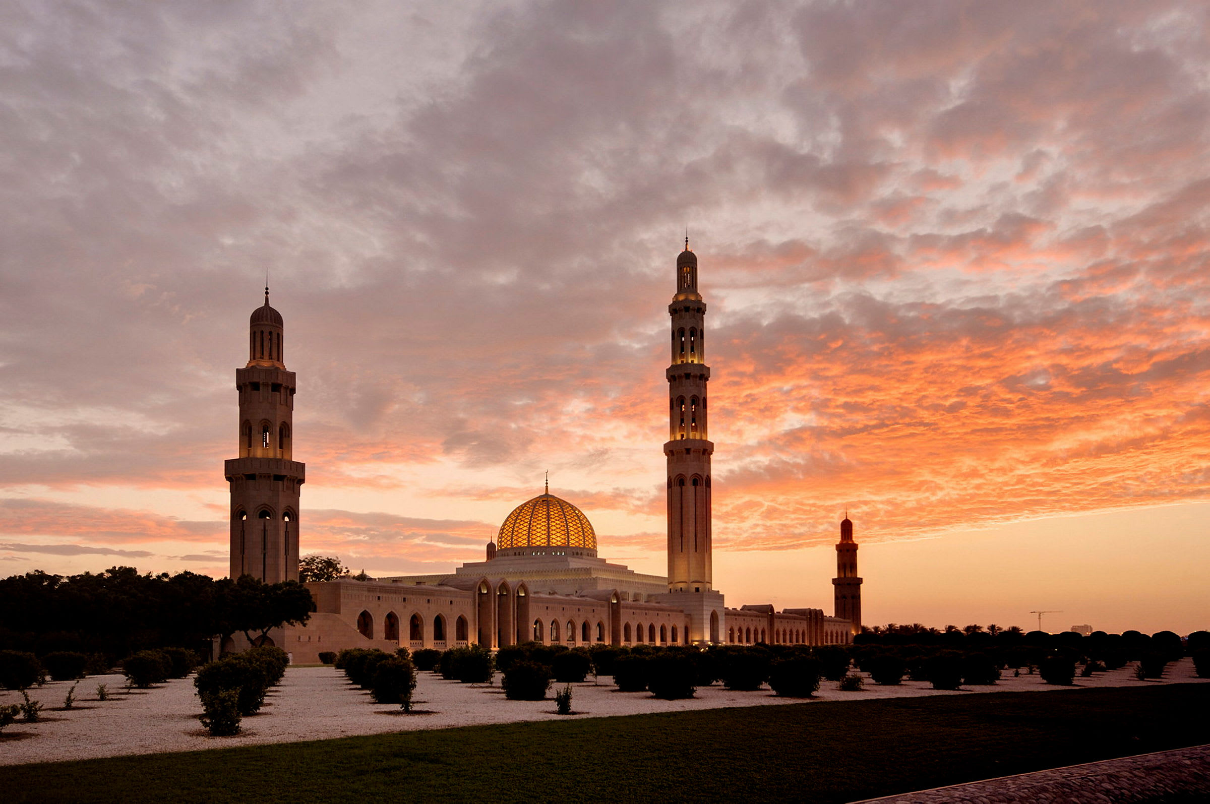 En moské med en kupol och minareter under en färgskiftande himmel vid solnedgång. (AI-genererad text)