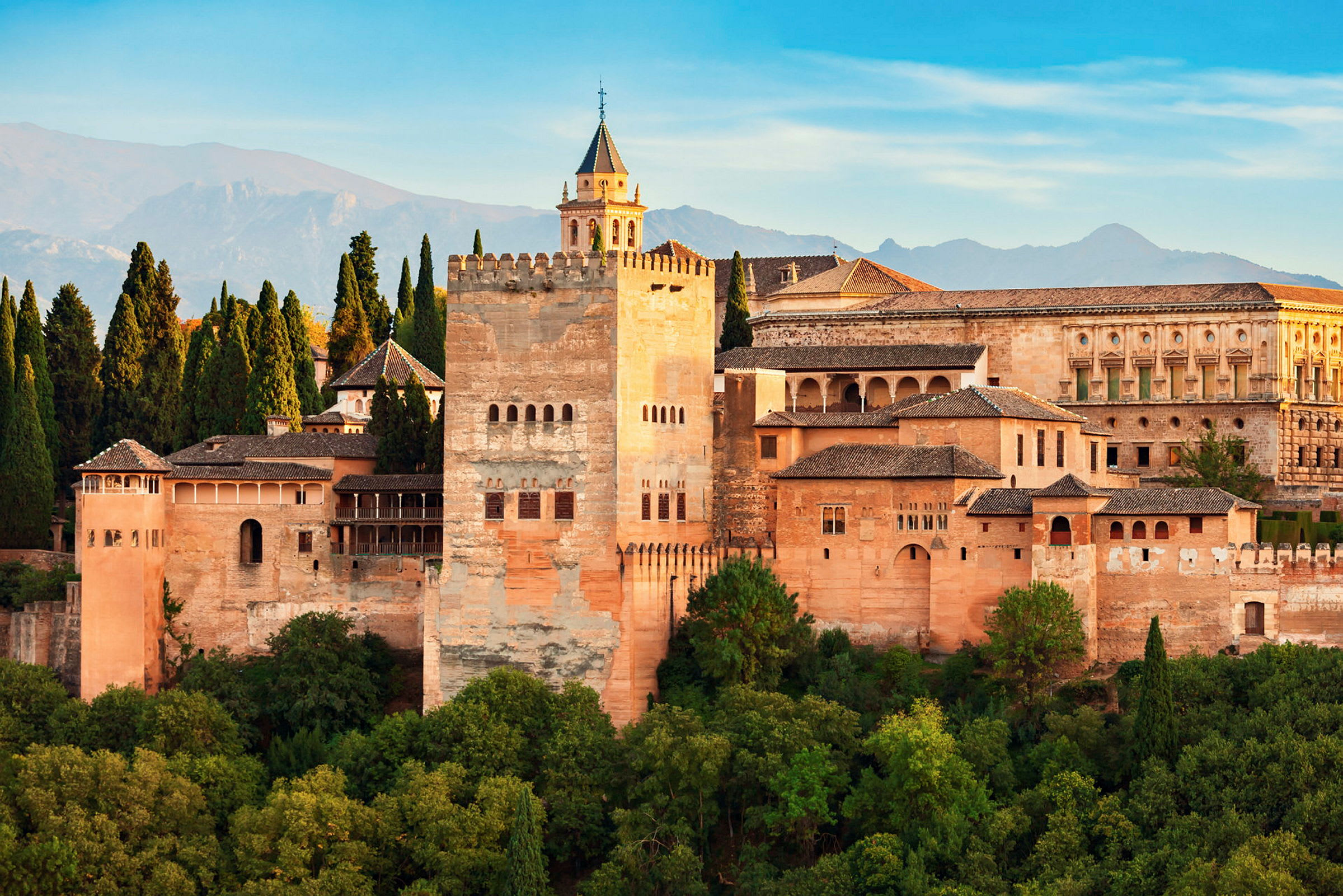 Bild av Alhambra med skog i förgrunden och berg i bakgrunden. (AI-genererad text)
