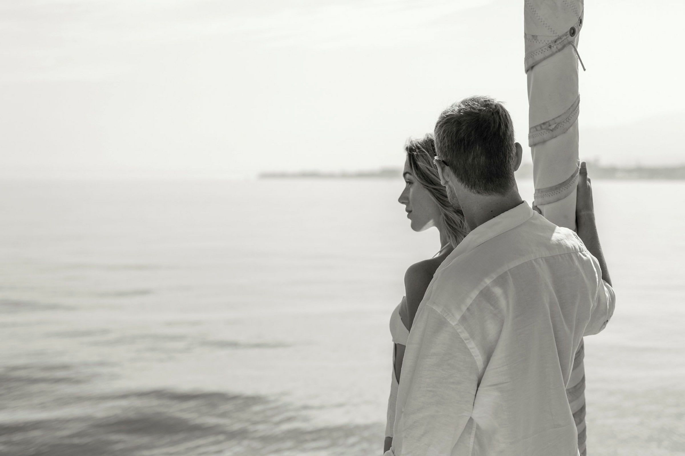 Personer står vid en strand och blickar ut över havet. (AI-genererad text)