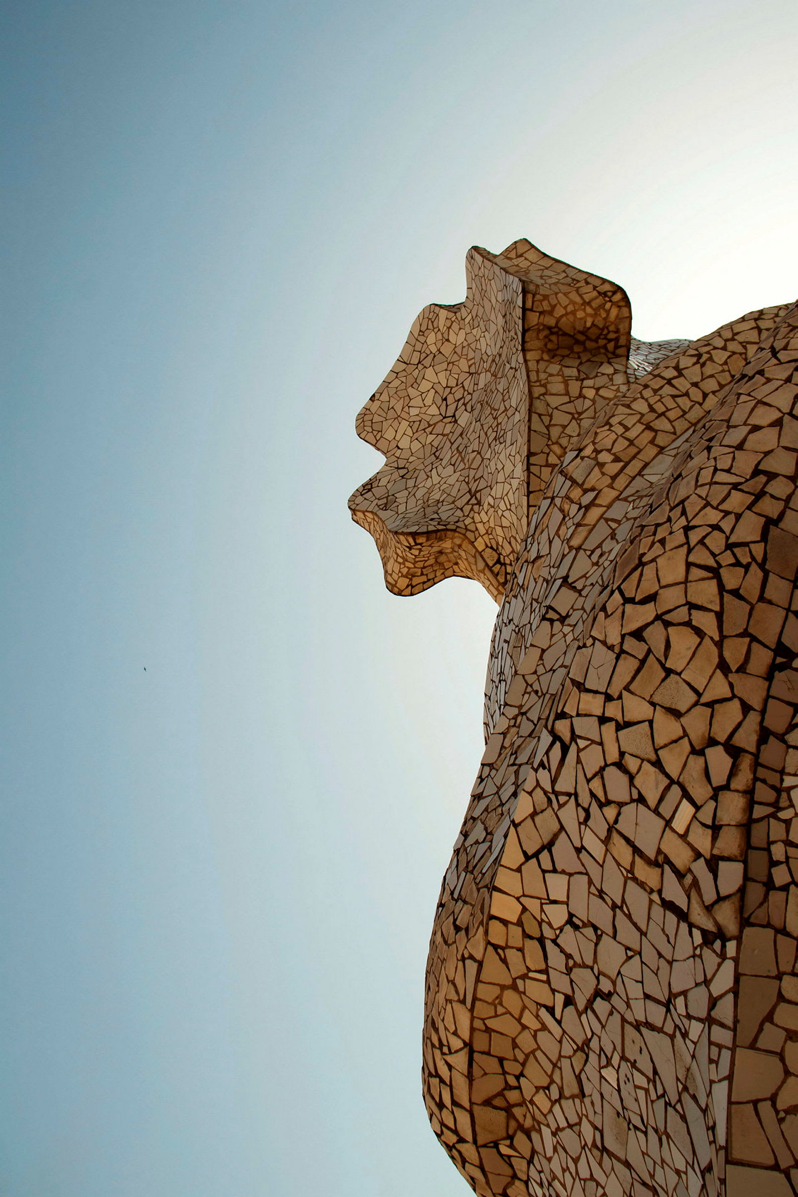 Mosaikdetalj på en skulptur med himmel som bakgrund. (AI-genererad text)