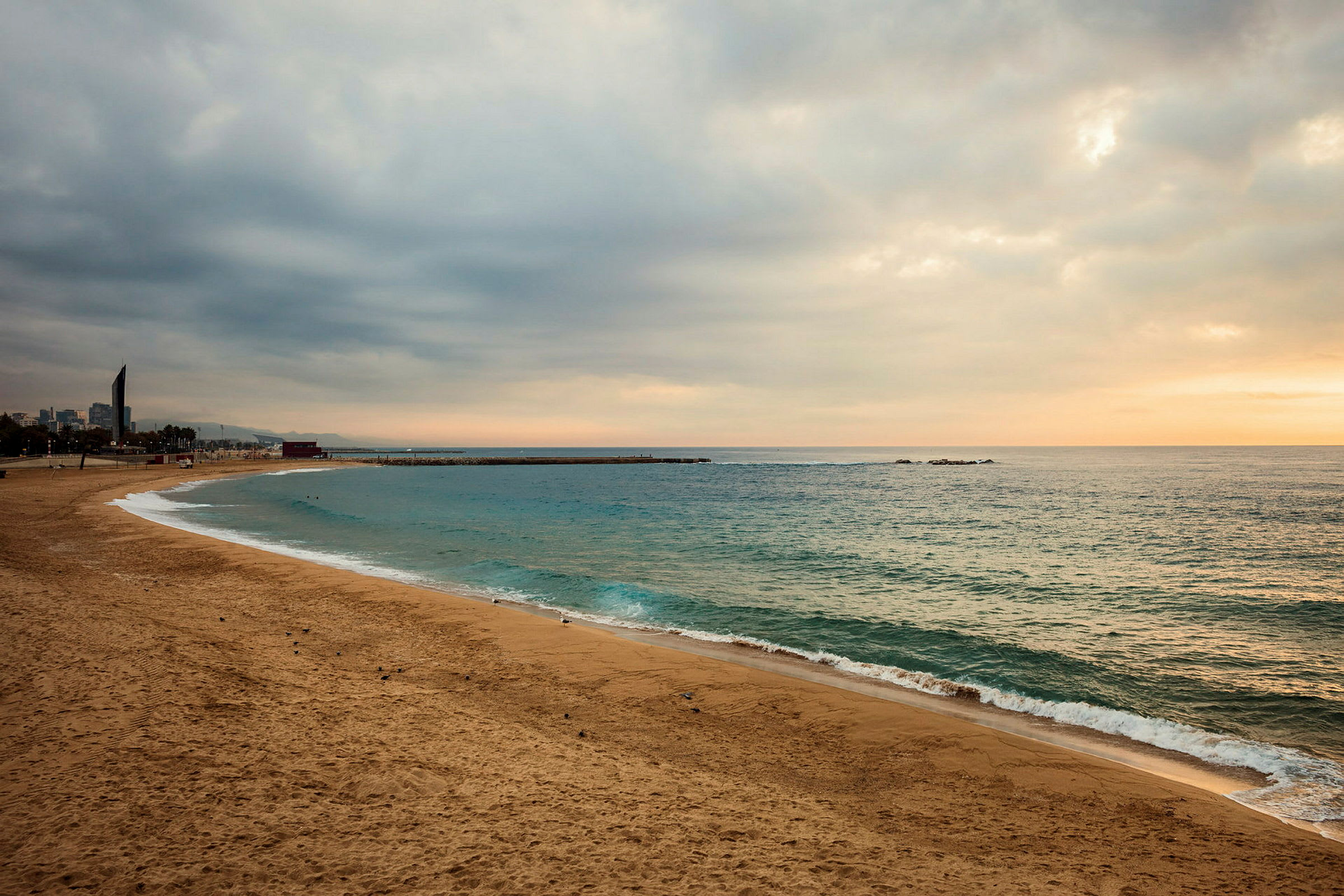En sandstrand vid havet under en mulen himmel. (AI-genererad text)
