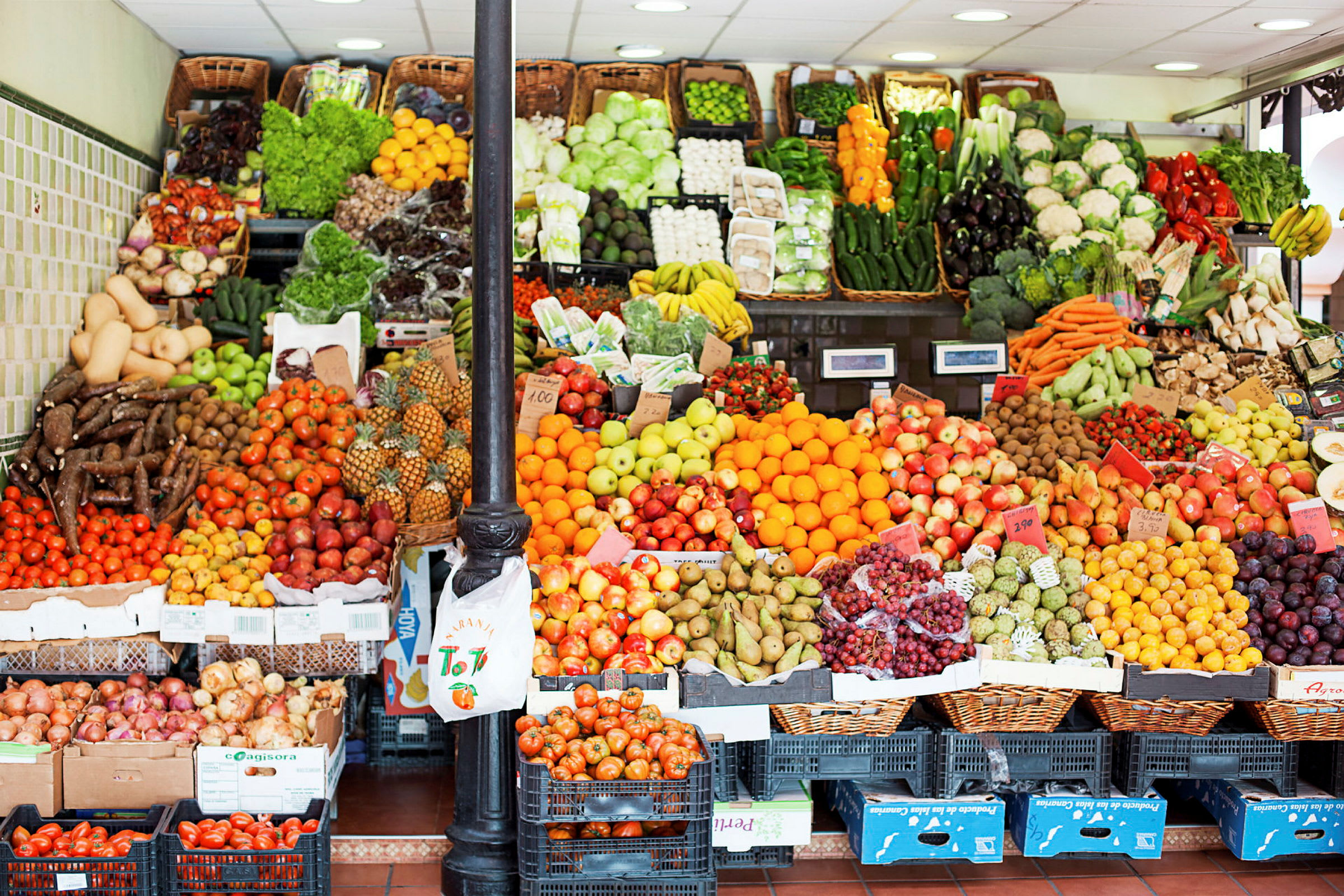 Frukt- och grönsaksstånd med olika färska varor arrangerade i korgar och lådor. (AI-genererad text)