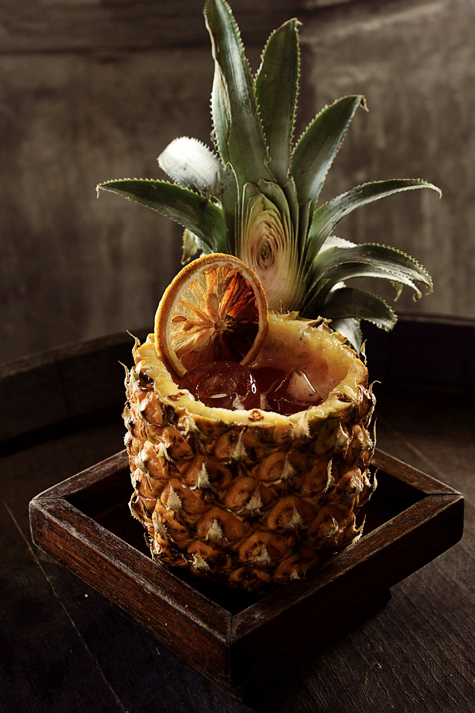 En drink serverad i en urholkad ananas med en citronskiva. (AI-genererad text)
