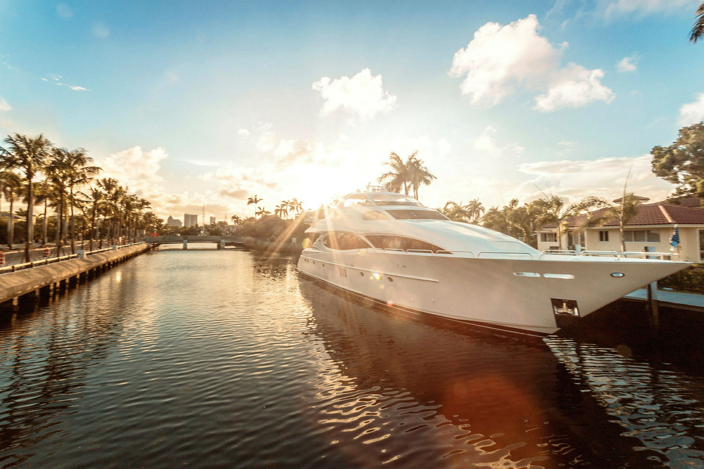 Stor modern yacht ankrad vid kaj i en solig kanal. (AI-genererad text)