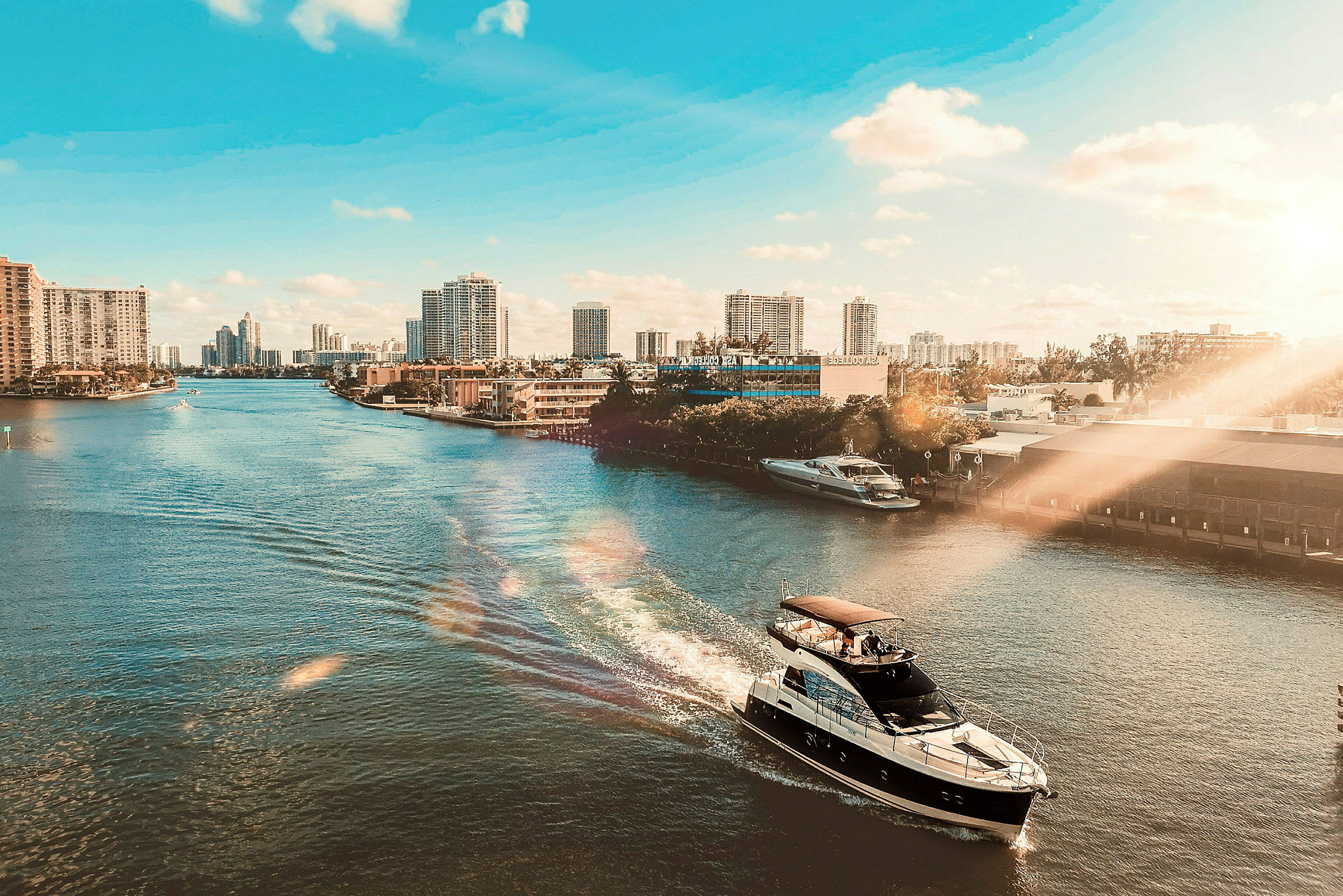 En yacht på en flod med stadssiluett i bakgrunden och klart väder. (AI-genererad text)