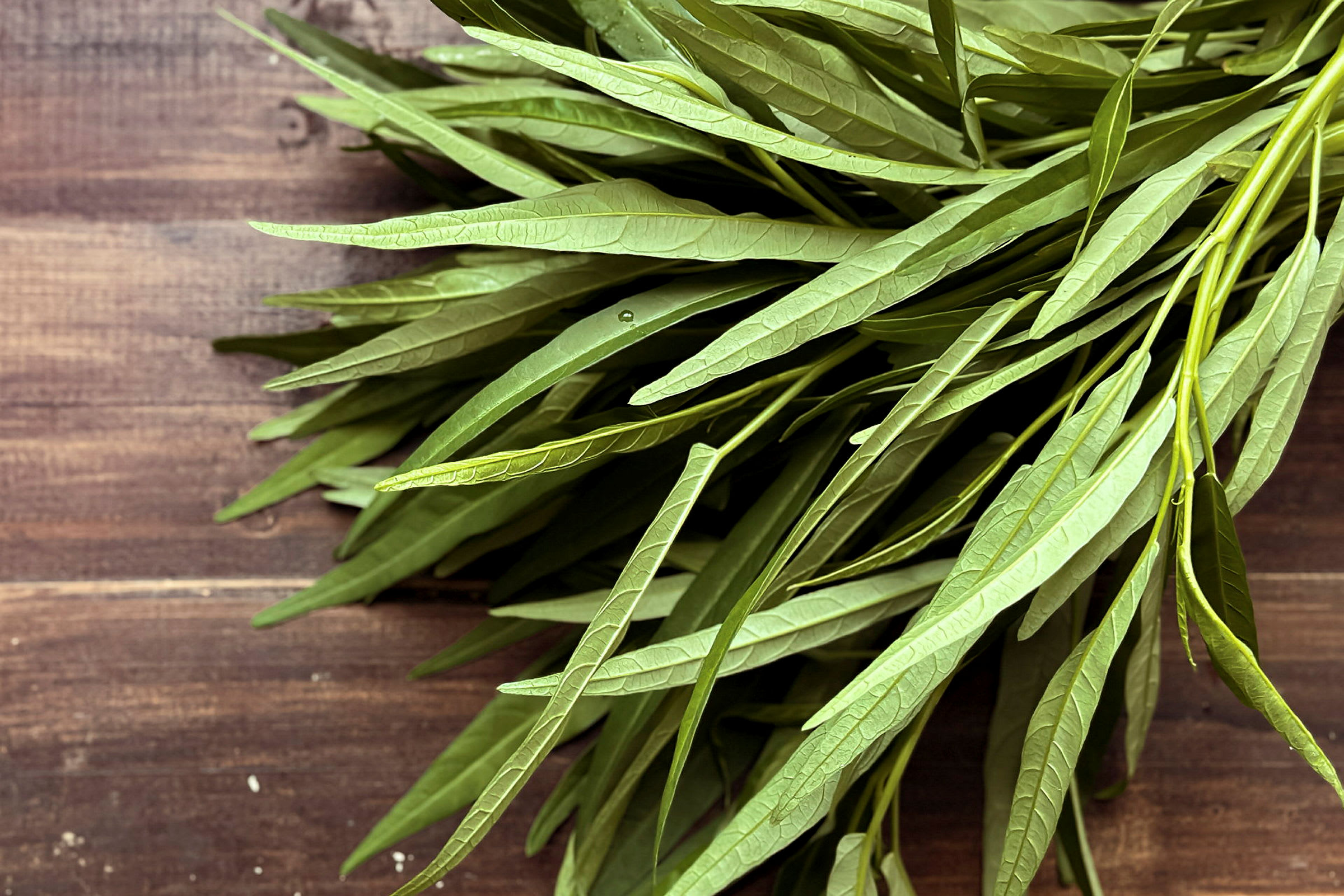 Färska gröna blad på en bordsyta av trä. (AI-genererad text)