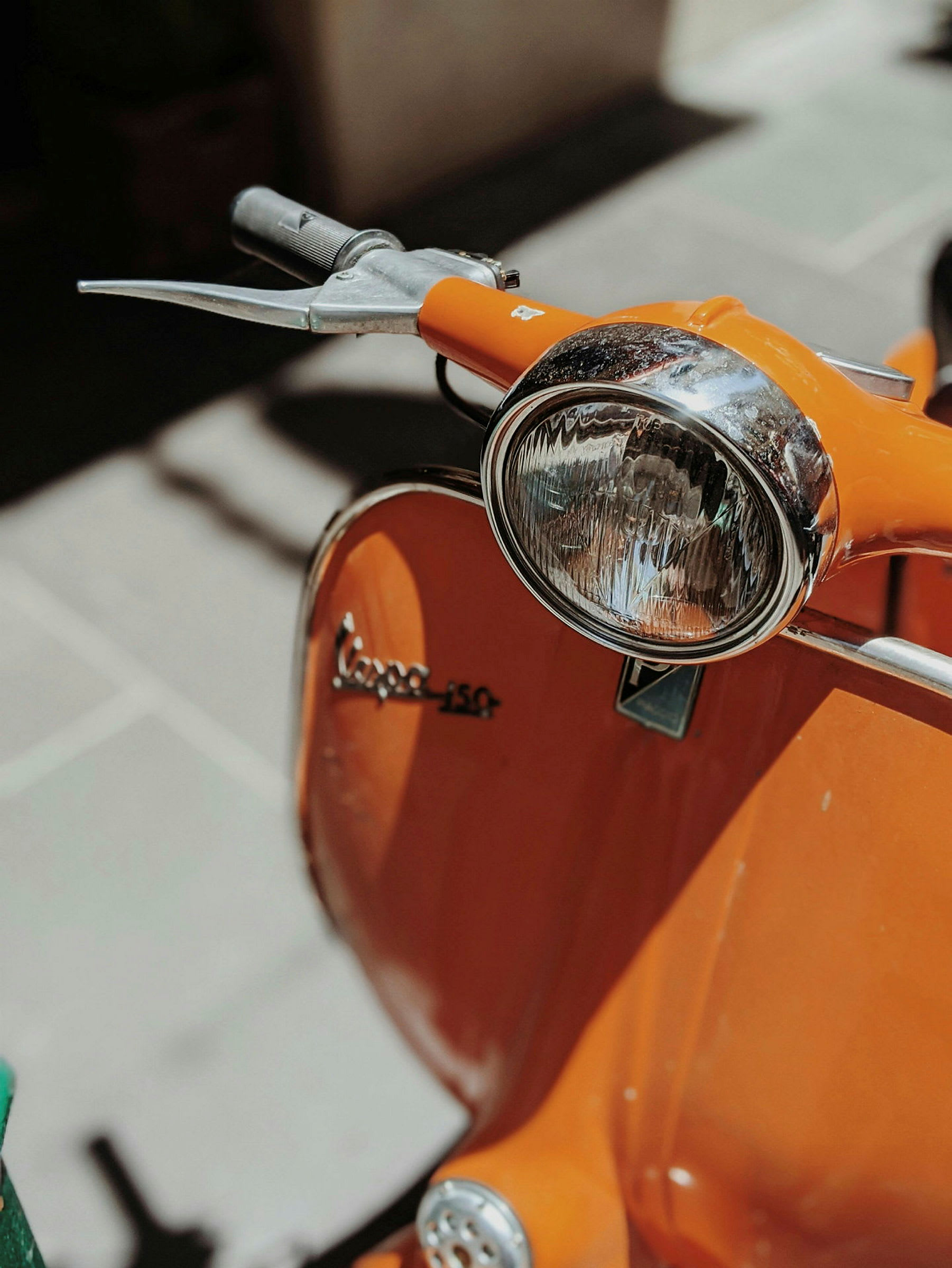 En orange Vespa-scooter fotograferad i närbild. (AI-genererad text)