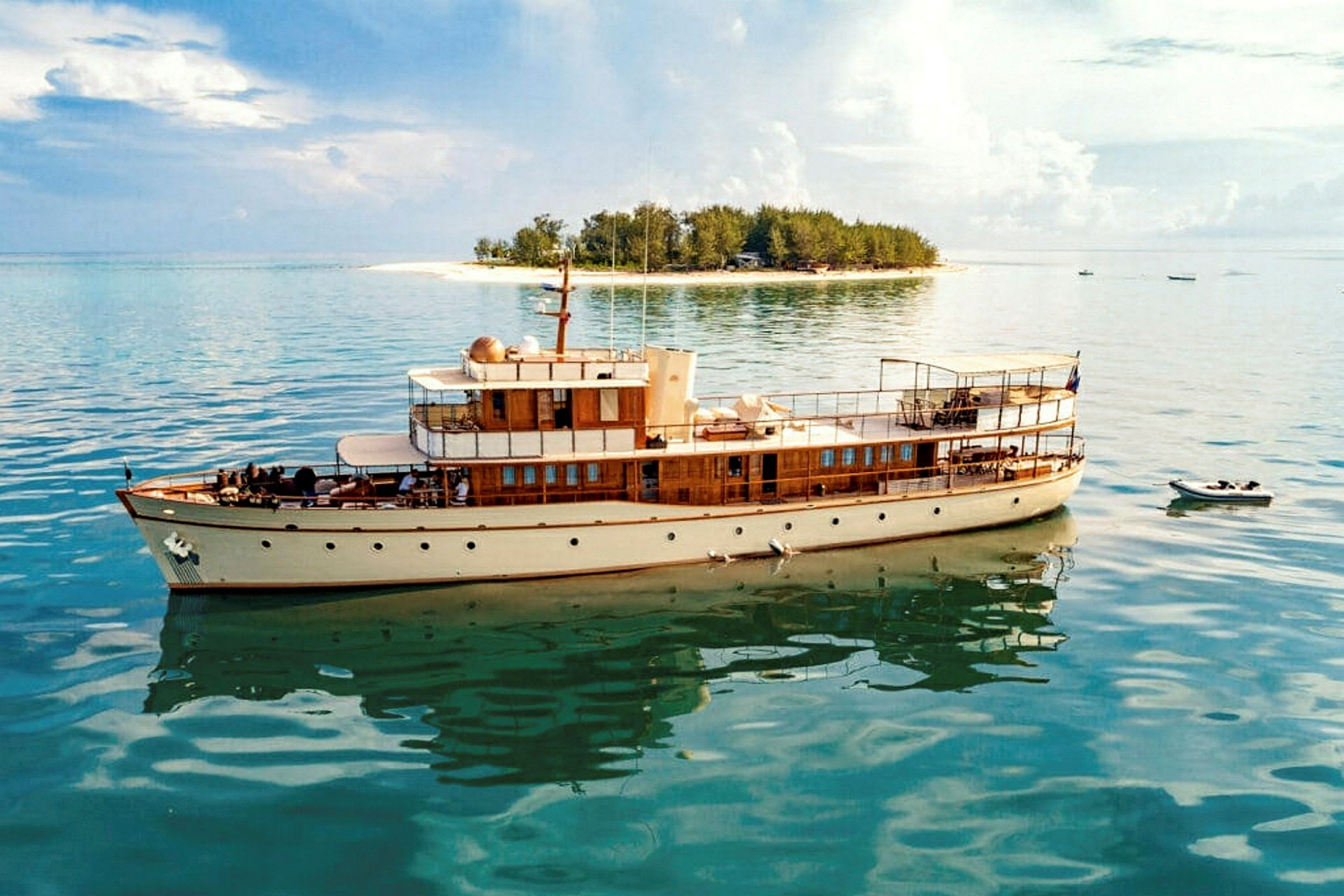 En yacht ligger stilla i vattnet nära en liten ö. (AI-genererad text)