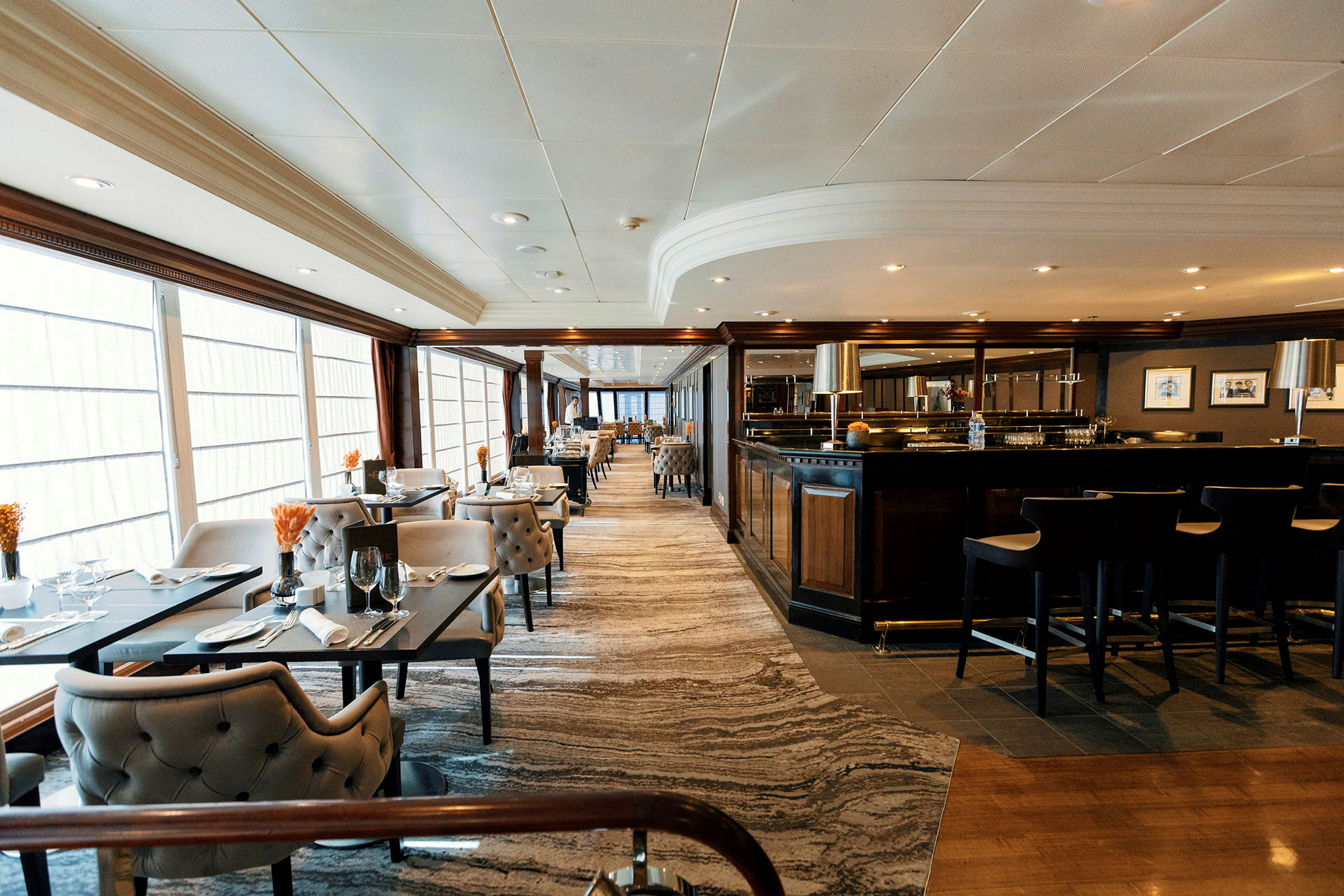 Elegant restaurang med bord, stolar och barområde. (AI-genererad text)