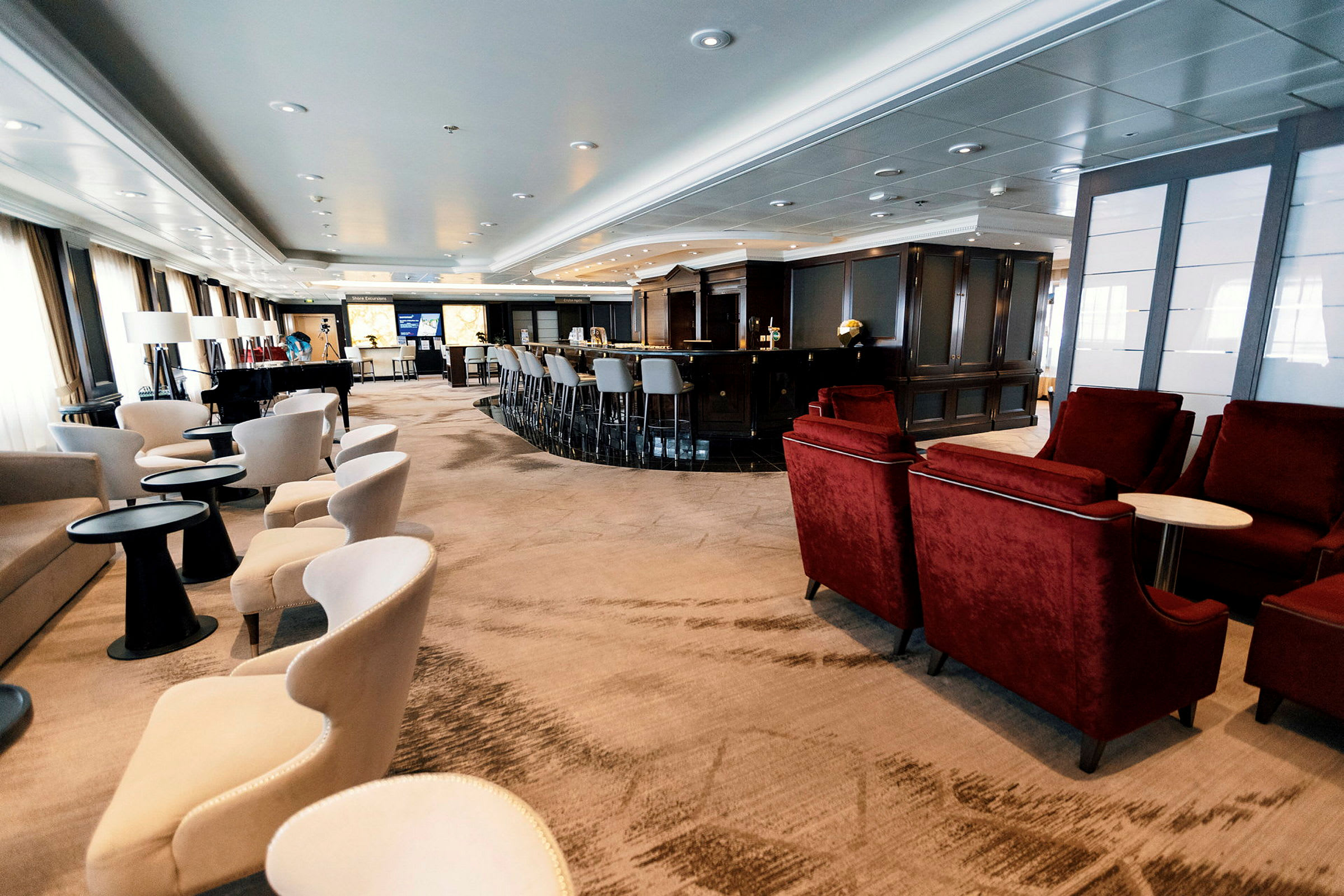Ett elegant loungeområde med soffor och fåtöljer, dämpad belysning och en bar. (AI-genererad text)
