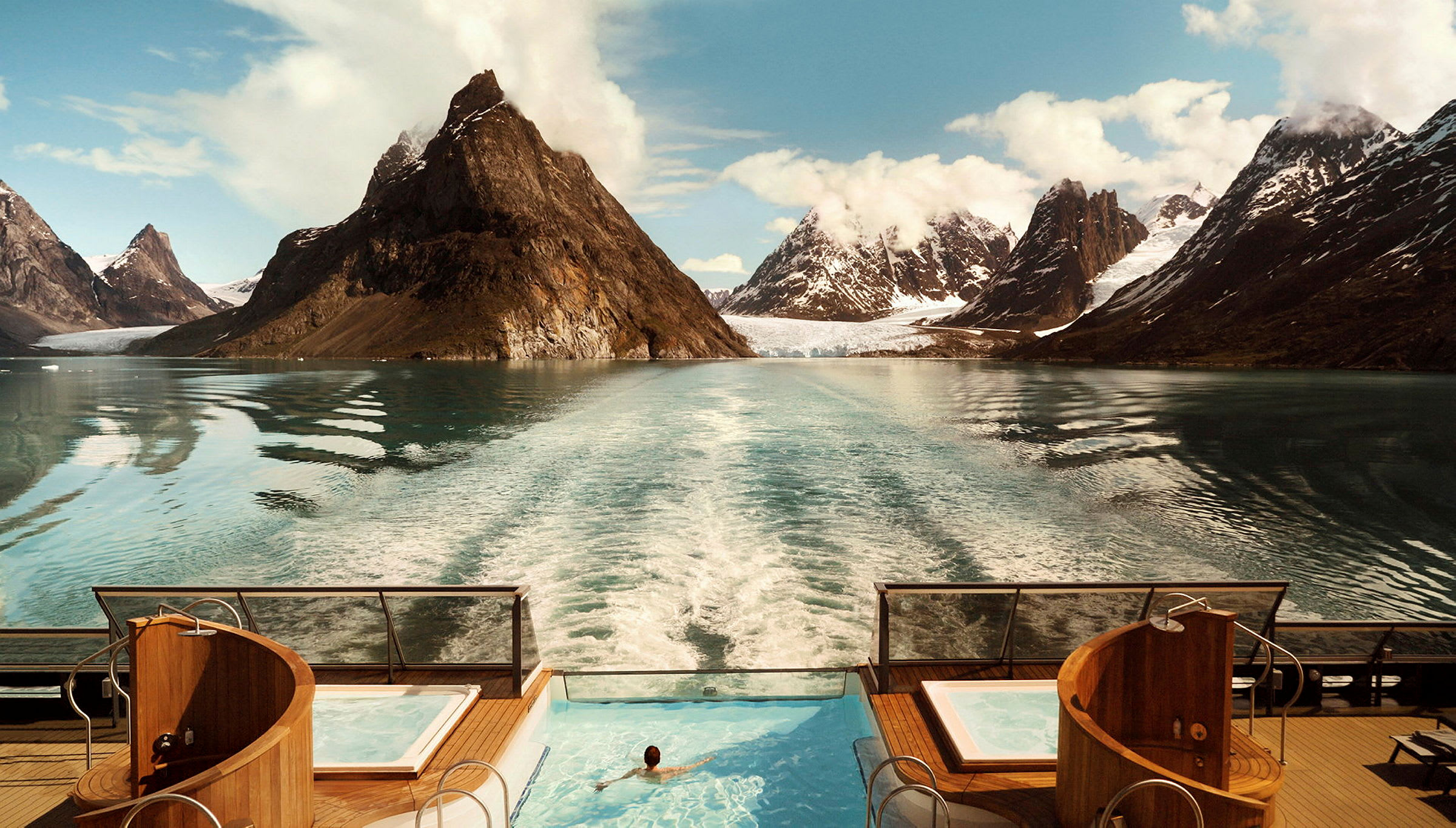 En pool ombord på en båt med utsikt över ett fjordlandskap med höga berg. (AI-genererad text)
